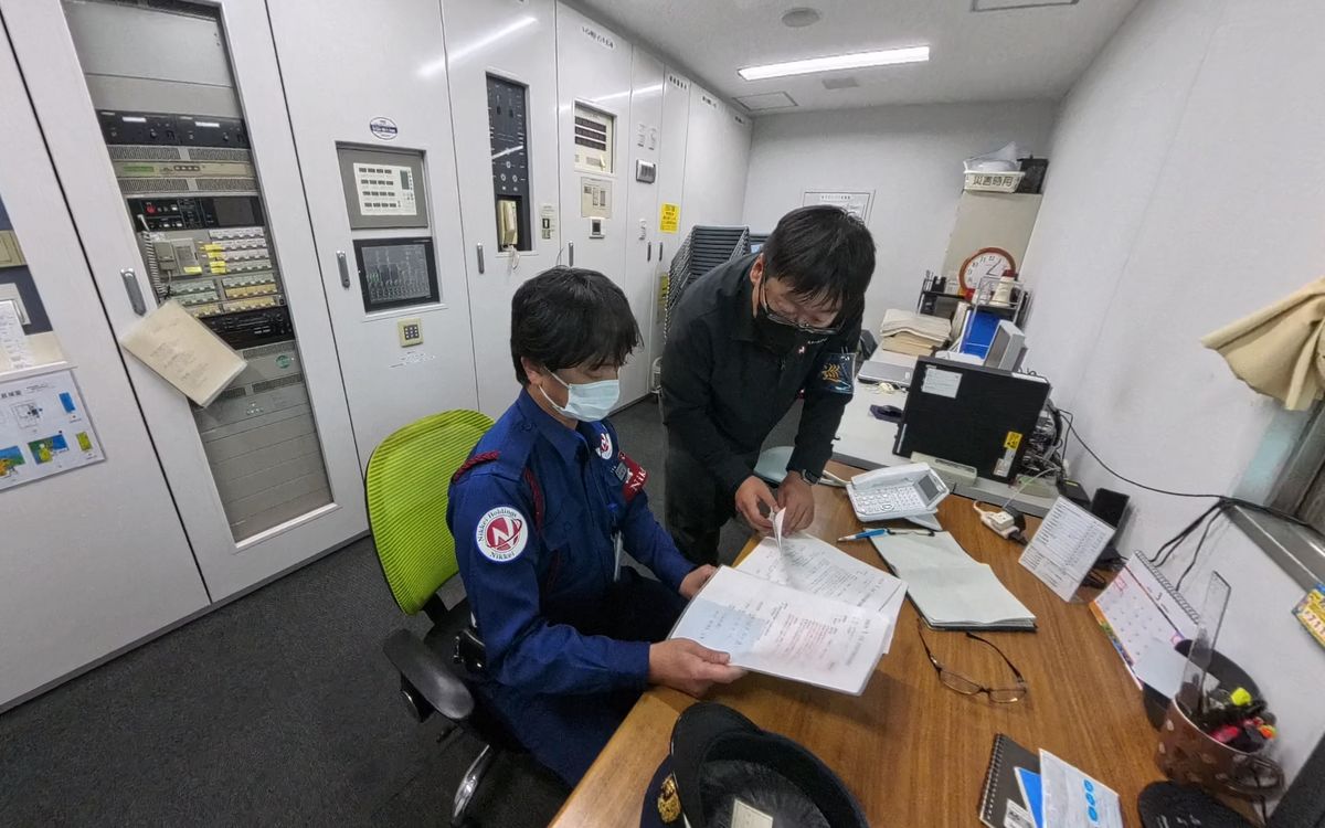 防災センターで書類を確認する警備スタッフ